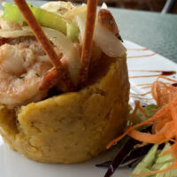 Mofongo - A traditional dish made with mashed green plantains, meat, and olive oil.